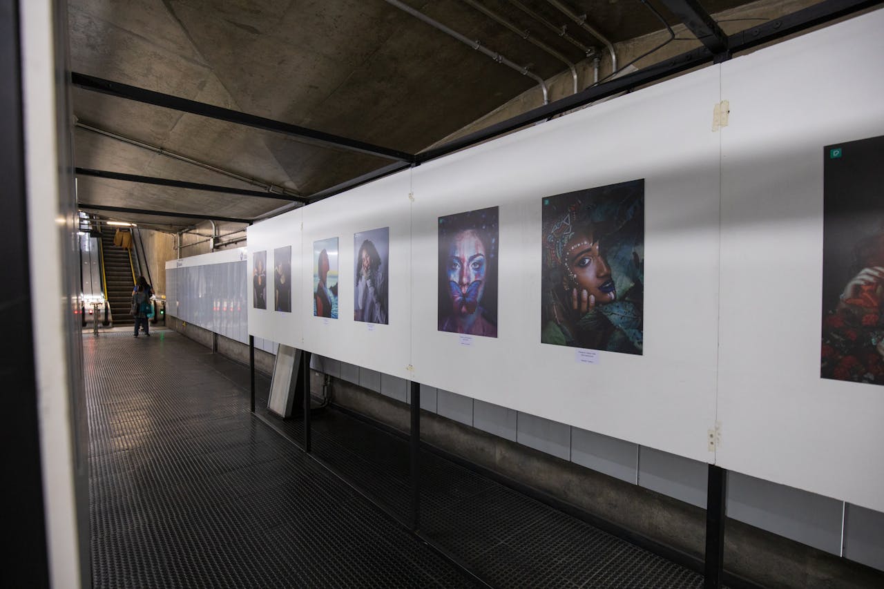 An underground art exhibition showcasing vibrant portrait photography on display.