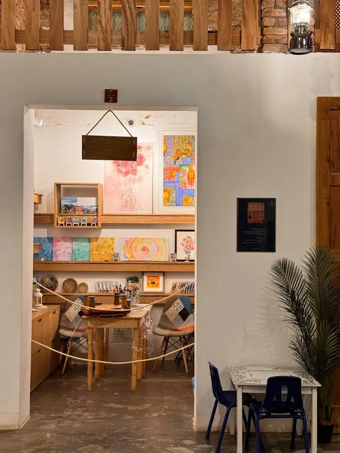 Airbnb vs exposition artistique : quel rendement ? Inviting art studio entrance showcasing colorful paintings and cozy furniture.