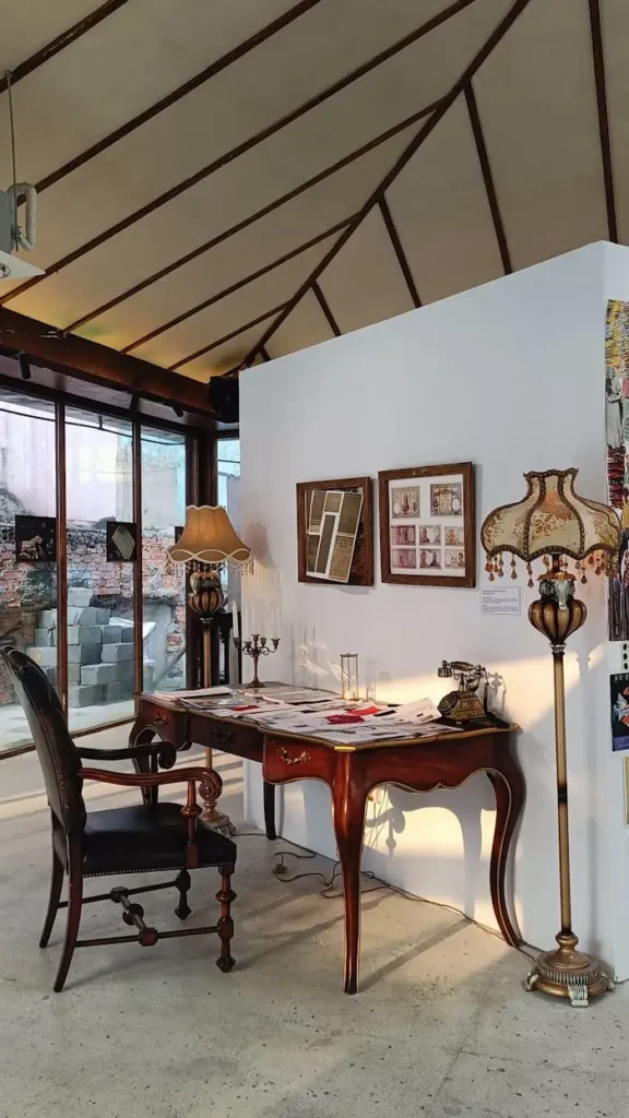 A vintage workspace featuring a wooden desk, antique chair, and classic decor illuminated by natural sunlight.